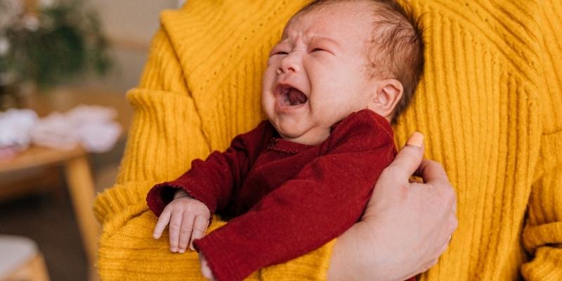 Em bé trai lạ bị ốm trong tay cần được chăm sóc